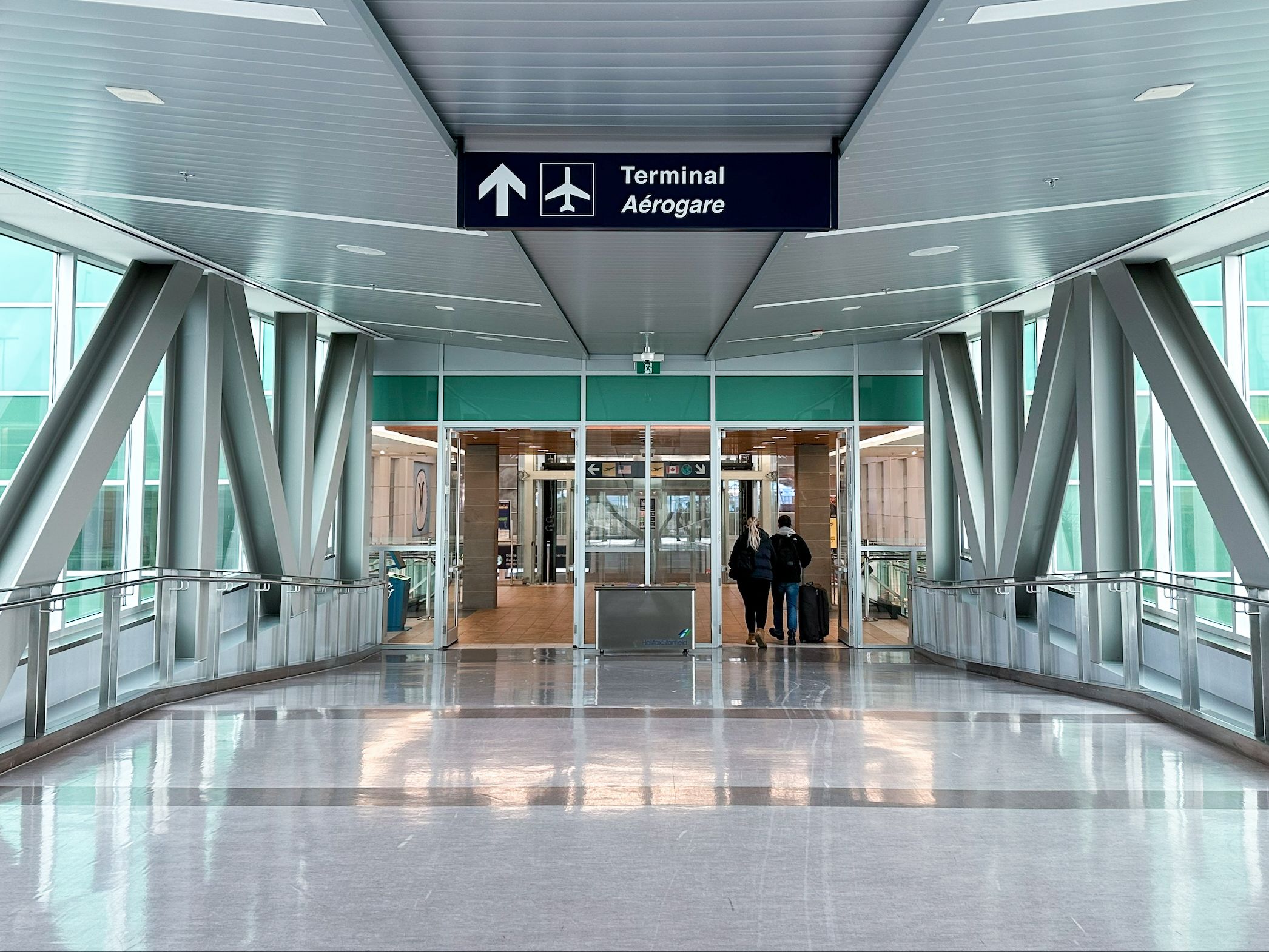 A pedway with signs directing people to the Airport Terminal